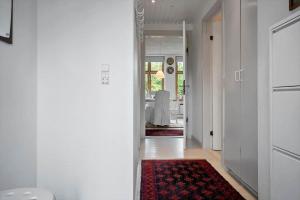 a hallway with white walls and a red rug at 4025-Borre-Liselundvej-20 in Borre +14 photos