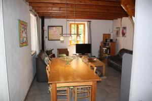 a living room with a wooden table and a dining room at Bergerie - piscine privée in Cadrieu