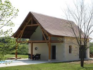 a small house with a wooden roof at Bergerie - piscine privée in Cadrieu