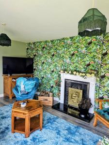 a living room with a fireplace and a large mural at The Little Green Hideaway in Fivemiletown