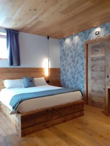 a bedroom with a bed in a wooden room at Affittacamere Sbulìa in Santo Stefano di Cadore +55 photos