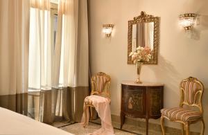 a bedroom with two chairs and a table and a mirror at Athenian Vintage Apartments in Athens