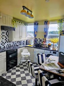 a kitchen with a checkered floor and a table and chairs at The Little Green Hideaway in Fivemiletown