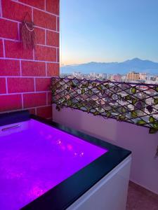 a hot tub with purple lights on a brick wall at Jacuzzi Central Apartment in Shkodër