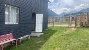 a house with a door and a bench next to it at Kolsay Camp House in Kurmenty