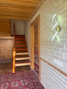 a room with a staircase and a brick wall at Kolsay Camp House in Kurmenty