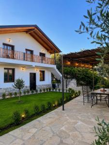 a house with a patio and a table in front of it at Villa Monte Shpirag in Berat