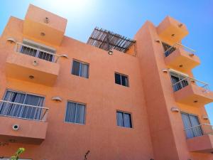 an orange building with balconies on top of it at Beach Condo 7- Upper Floor near Balandra fast WiFi in La Paz
