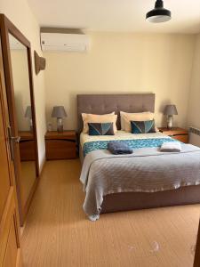 una camera da letto con un grande letto e due comodini di Refúgio do mineiro a Arouca