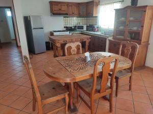 a kitchen with a wooden table and chairs and a refrigerator at Beach Condo 7- Upper Floor near Balandra fast WiFi in La Paz