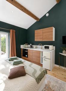 a kitchen with green walls and a large bed at Suite Sunan in Toulon