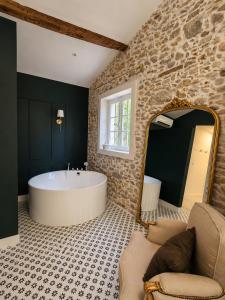 a bathroom with a large tub and a mirror at Suite Sunan in Toulon