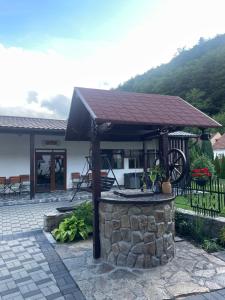 a pavilion with a roof on top of a stone wall at La Turcu in Văliug