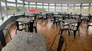 a restaurant with tables and chairs and a red truck at Moorside Hotel and Cafe in Stoupe Brow