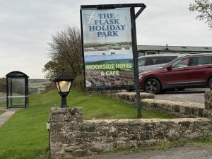 a sign for the flash holiday park next to a parking lot at Moorside Hotel and Cafe in Stoupe Brow