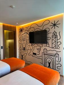 a bedroom with a wall mural with a tv on it at Le M Neo in Rabat
