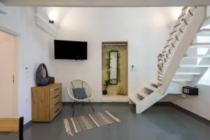 a living room with a staircase and a chair at Loft Kaves Pool & Bar Suites in Pyrgos