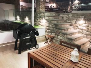 a grill in a room with a stone wall at Lithos House & Spa in Nafpaktos