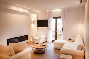 a living room with white furniture and a fireplace at Lithos House & Spa in Nafpaktos
