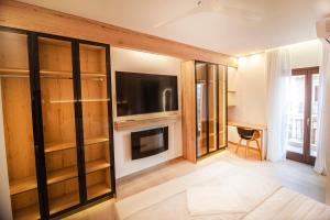 a living room with a tv and some glass shelves at Lithos House & Spa in Nafpaktos +18 photos