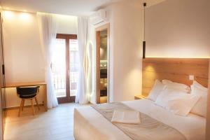 a bedroom with a bed and a desk and a chair at Lithos House & Spa in Nafpaktos