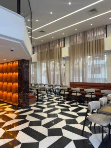 a lobby with chairs and tables on a checkered floor at Le M Neo in Rabat