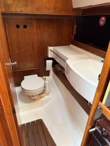 a small bathroom with a toilet and a sink at Fully equipped sailing boat & exploring zodiac in Nyon +12 photos