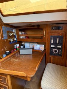 a small kitchen with a wooden counter and a table at Fully equipped sailing boat & exploring zodiac in Nyon
