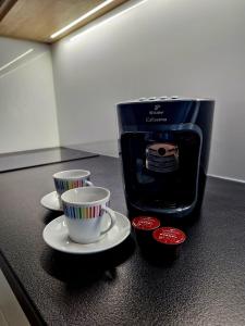 a black counter with two cups and a coffee maker at Apartmán Hestia 5 in Rajecké Teplice
