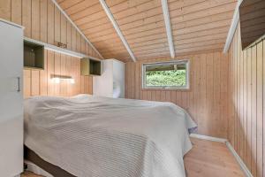 a bedroom with a bed in a room with a window at C11267-Hemmet-Egernvej-12 in Henne Strand