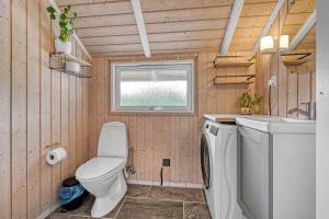 a small bathroom with a toilet and a sink at C11267-Hemmet-Egernvej-12 in Henne Strand +28 photos