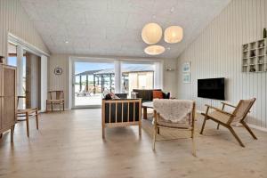 a living room with a table and chairs at 30454-Odder-Saksild-Strandfaelled-51 in Dyngby