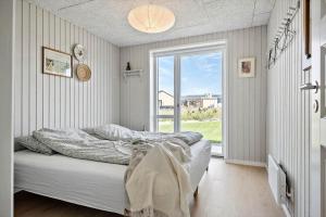 a bedroom with a bed and a large window at 30454-Odder-Saksild-Strandfaelled-51 in Dyngby
