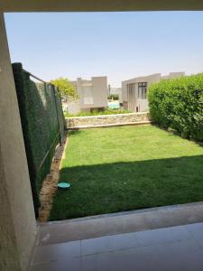 a yard with a fence and a frisbee on the grass at Azha Townhouse in Ain Sokhna +5 photos