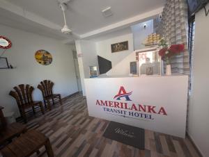 a sign for anarma transfer hotel in a room with chairs at AmeriLanka Transit Hotel in Seeduwa