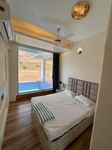 a bedroom with a bed and a large window at Avera luxurious stay in Igatpuri +14 photos