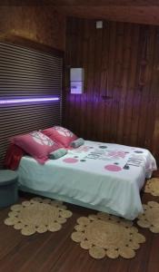 a bedroom with a bed with rugs on the floor at Baril O'thentik Gîte et Bungalow in Saint-Philippe