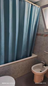 a bathroom with a blue shower curtain and a toilet at lo flamenc @Amposta in Amposta