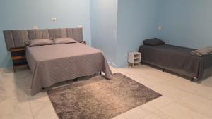 a bedroom with two beds and a rug at Pousada Vale do Sol in Pariqueraçu