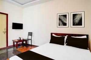 a bedroom with a bed and a chair and a desk at SPOT ON Sj Comforts Boarding And Lodging in Jigani +21 photos