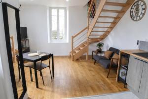 a living room with a table and a staircase at Le temps d'une pause -1- in Cepoy
