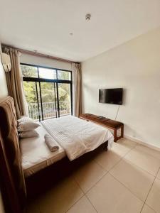 a bedroom with a bed and a large window at LUXIRIOUS Homes in Dar es Salaam