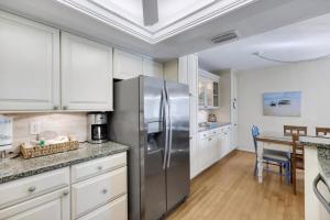 a kitchen with a stainless steel refrigerator and a table at Compass Point 221 in Sanibel