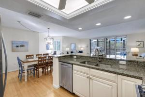 a kitchen with a sink and a dining room at Compass Point 221 in Sanibel +22 photos