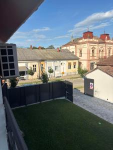 a view of a yard with a fence and a building at Apartmani Rosa in Rača