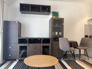 a room with a desk and a table and chairs at Apartmani Rosa in Rača