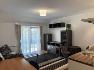 a kitchen and living room with a table and chairs at Apartmani Rosa in Rača