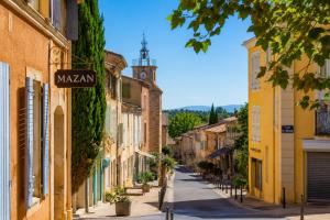 a street in a town with yellow buildings at Studio le 174 in Mazan