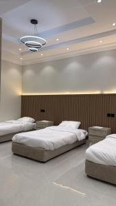 a bedroom with two beds and a chandelier at شقة سحاب ابها in Abha