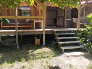 a house with a porch and stairs in the yard at Wiesenrand in Neukalen